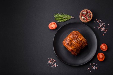 Delicious fresh smoked meat or ham with spices and herbs on a dark concrete background