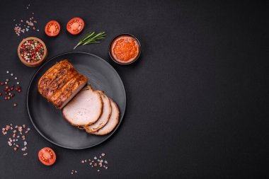 Delicious fresh smoked meat or ham with spices and herbs on a dark concrete background