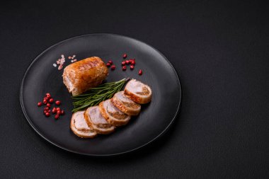 Delicious chicken or pork meat roll with mushrooms, cheese, spices and herbs on a dark concrete background