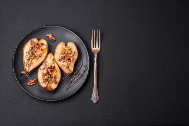 Delicious baked pear with dorblu cheese, walnut and honey on a textured concrete background. Vegetarian dish