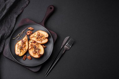 Delicious baked pear with dorblu cheese, walnut and honey on a textured concrete background. Vegetarian dish
