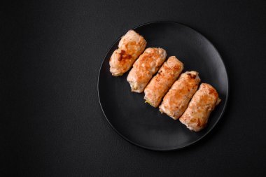Delicious baked pork or chicken roll with mushrooms, spices and herbs inside on a dark concrete background