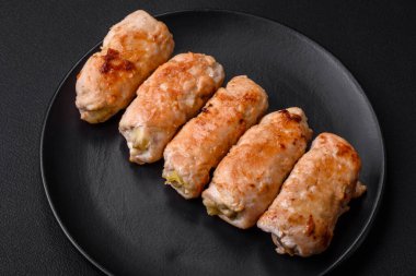 Delicious baked pork or chicken roll with mushrooms, spices and herbs inside on a dark concrete background