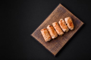 Delicious baked pork or chicken roll with mushrooms, spices and herbs inside on a dark concrete background