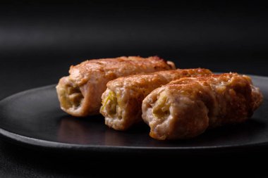 Delicious baked pork or chicken roll with mushrooms, spices and herbs inside on a dark concrete background