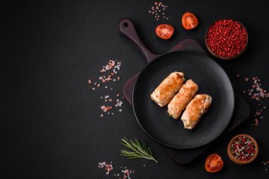 Delicious baked pork or chicken roll with mushrooms, spices and herbs inside on a dark concrete background