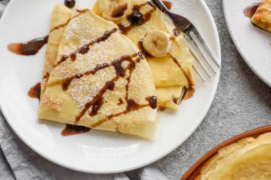 Delicious fresh baked pancakes with honey and fruits on a textured concrete background. Useful healthy food