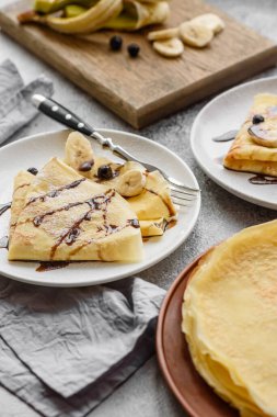 Delicious fresh baked pancakes with honey and fruits on a textured concrete background. Useful healthy food