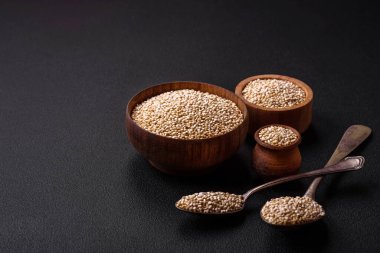 Wholesome raw quinoa in a bowl on a dark concrete background. Useful healthy food