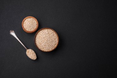 Wholesome raw quinoa in a bowl on a dark concrete background. Useful healthy food
