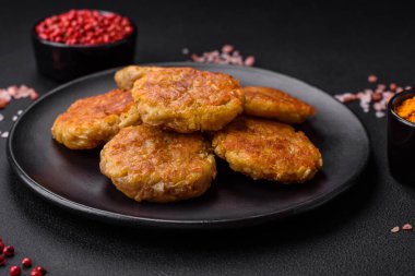 Koyu bir zeminde patates, havuç, soğan ve fasulye içeren pirzola ya da köfte şeklinde lezzetli, sağlıklı vejetaryen ya da vejetaryen yemekleri.