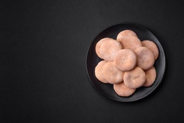 Delicious fresh baked cornmeal shortcakes or cookies on a black ceramic plate on a dark concrete background