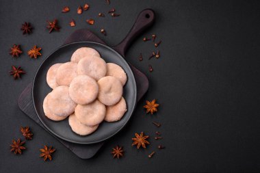 Delicious fresh baked cornmeal shortcakes or cookies on a black ceramic plate on a dark concrete background