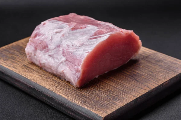 新鲜多汁的猪肉放在木制切菜板上 在深色混凝土背景上加香料和盐 — 图库照片