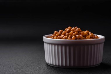 Lezzetli sağlıklı konserve mercimekler seramik bir kaburgalı beyaz kase üzerinde koyu beton arka planda