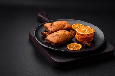 Lezzetli çikolatalı kekler ve koyu dokuda parlak turuncu renkli mandalina dilimleri.