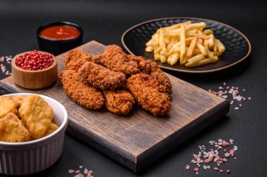 Lezzetli gevrek tavuk kanatları. Koyu beton bir arka planda baharat ve otlarla ızgara.