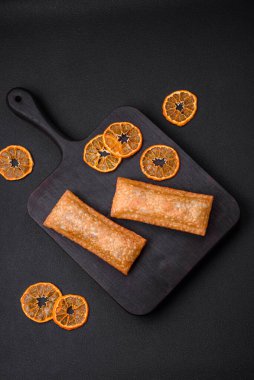 Tahta kesme tahtasının üzerinde kiraz reçelli lezzetli çıtır turta, koyu beton arka planda.