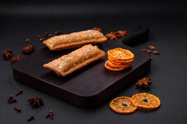 Tahta kesme tahtasının üzerinde kiraz reçelli lezzetli çıtır turta, koyu beton arka planda.