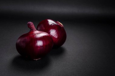 Koyu desenli beton zeminde taze kırmızı soğan. Evde yemek pişirmek.