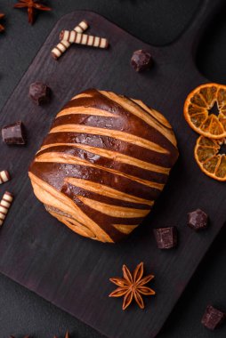 Lezzetli, çıtır çıtır, taze tarçınlı çörek, koyu beton arka planda.