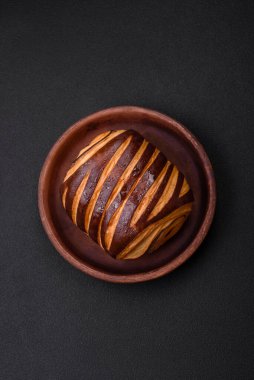 Lezzetli, çıtır çıtır, taze tarçınlı çörek, koyu beton arka planda.