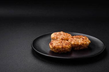 Lezzetli taze pirzola ya da baharatlı köfte, bitki ve domates soslu koyu beton arka planda.