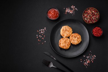 Lezzetli taze pirzola ya da baharatlı köfte, bitki ve domates soslu koyu beton arka planda.