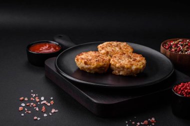 Lezzetli taze pirzola ya da baharatlı köfte, bitki ve domates soslu koyu beton arka planda.