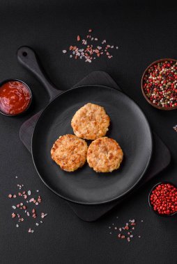 Lezzetli taze pirzola ya da baharatlı köfte, bitki ve domates soslu koyu beton arka planda.