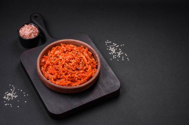 Kurutulmuş mürekkep balığı dilimlenmiş ve koyu beton arka planda susam tohumu ve baharatla tatlandırılmış. Kore mutfağı.