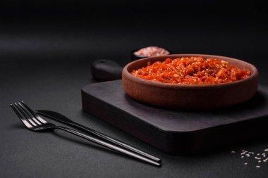 Kurutulmuş mürekkep balığı dilimlenmiş ve koyu beton arka planda susam tohumu ve baharatla tatlandırılmış. Kore mutfağı.