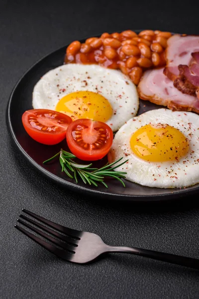 美味的有营养的英式早餐 有煎蛋 西红柿 熏肉和豆子 背景是深色混凝土的 — 图库照片