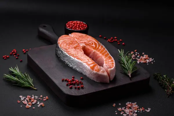 濃いコンクリートの背景にスパイスやハーブと新鮮な生の赤魚のステーキ — ストック写真