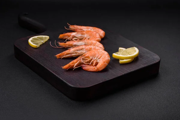 stock image Tiger shrimp or langoustine boiled with spices and salt on a dark concrete background