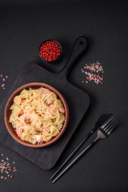 Lagoustine karidesli nefis farfalle makarna krem soslu ve peynirli koyu beton arka planda.