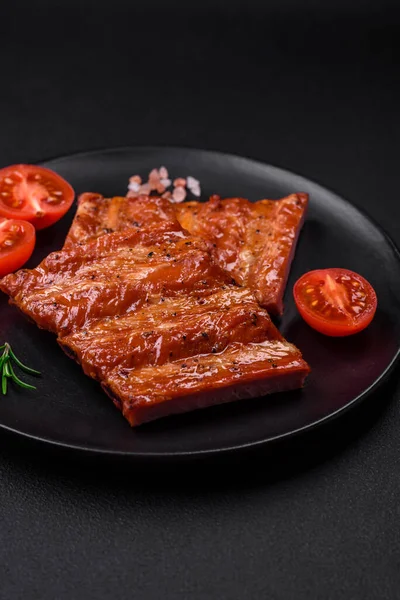 stock image Delicious fresh grilled or smoked ribs with salt, spices and herbs on dark concrete background