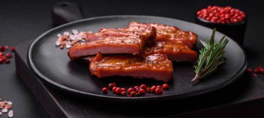 Koyu beton arka planda tuzlu, baharatlı ve otlu ızgara taze pirzola.