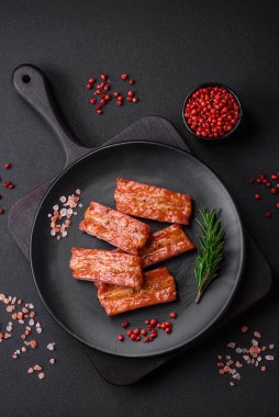 Koyu beton arka planda tuzlu, baharatlı ve otlu ızgara taze pirzola.