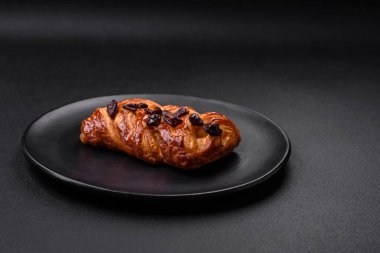 Koyu beton arka planda fındık ve şuruplu lezzetli fırında pişmiş at kuyruğu çöreği.