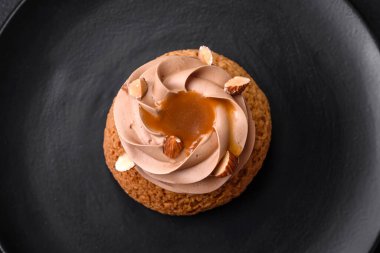 Koyu beton arka planda kremalı ve fındıklı lezzetli shu keki