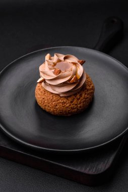 Koyu beton arka planda kremalı ve fındıklı lezzetli shu keki