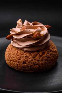 Koyu beton arka planda kremalı ve fındıklı lezzetli shu keki