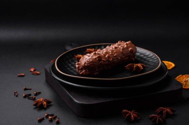 Lezzetli taze pasta ya da koyu beton arka planda çikolata ve fındıklı profiterol.