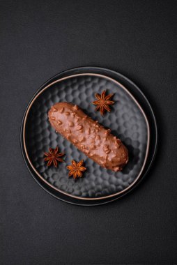 Lezzetli taze pasta ya da koyu beton arka planda çikolata ve fındıklı profiterol.