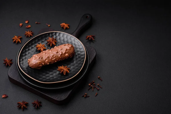 Lezzetli taze pasta ya da koyu beton arka planda çikolata ve fındıklı profiterol.