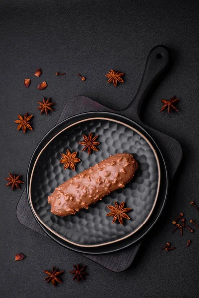 Lezzetli taze pasta ya da koyu beton arka planda çikolata ve fındıklı profiterol.