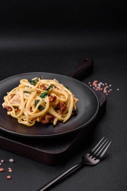 Ispanaklı, güneşte kurutulmuş domatesli, peynirli, soğanlı, baharatlı ve çimento kaplı lezzetli bir makarna.