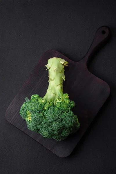 stock image Raw fresh broccoli on a black home kitchen table. Cooking vegan food