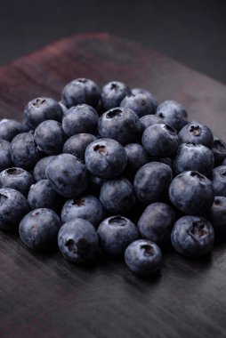 Taze yaban mersinleri ve siyah beton bir arka plan. Mevsimlik böğürtlen toplamak